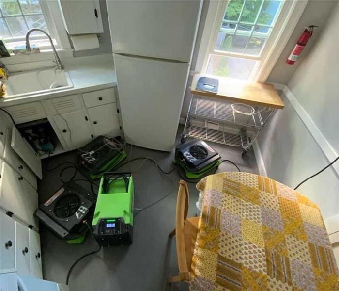 Three SERVPRO air movers and one dehumidifier in a kitchen