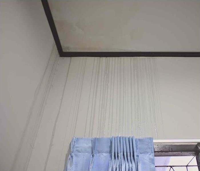a leak in ceiling creating water lines running down an interior wall